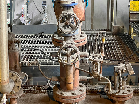 Valves and other safety equipment on an old steam boiler. Extensive wear, corrosion and contamination of the equipment and the boiler.