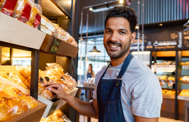 istock Retail clerk working at a bakery and restocking the shelves 2150044381