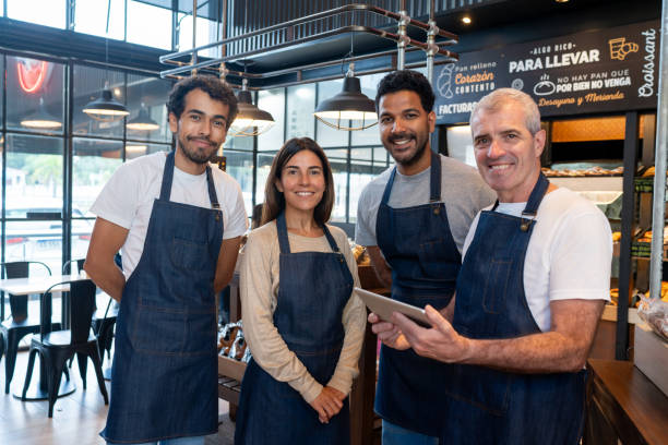 istock Group of employees working at a cafe and smiling 2150044407