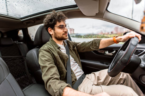 istock Happy handsom man looking away while driving his car. 2150046061