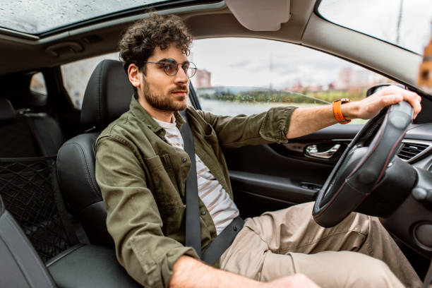 istock Happy handsom man looking away while driving his car. 2150046062