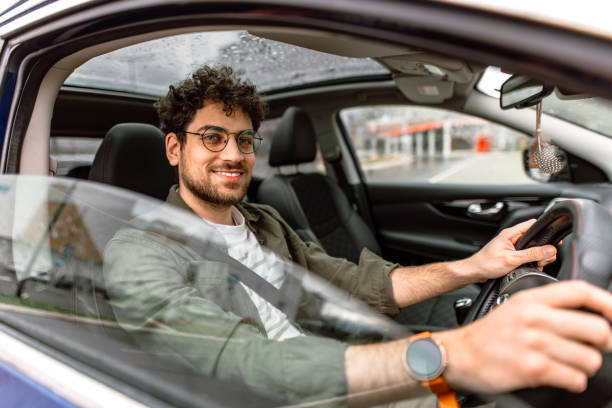 istock Young man driving a car in city. 2150046067