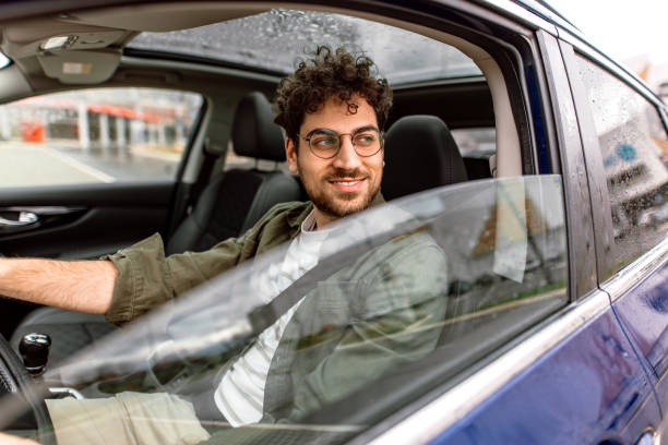 istock Young man driving a car in city. 2150046079