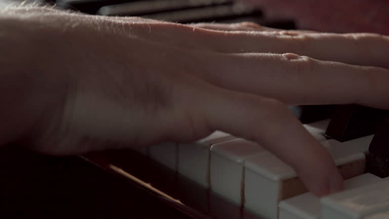 Close-up of hands of young pianist learning to play piano. Hand on piano keys. Music and hobby
