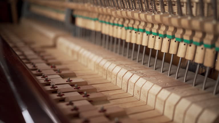 Close-up of musical mechanism of piano. Inside of old piano before tuning