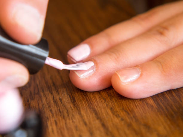 istock girl paints her nails with polish 2150057332
