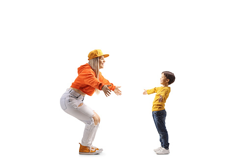 Full length profile shot of a little boy meeting a young female isolated on white background