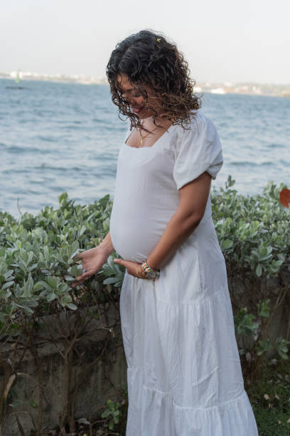istock Expectant Mother Caressing Belly by the Lake 2150060455