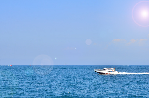 The speedboat sailing in the deep blue sea combined with the beautiful view of the sky.
