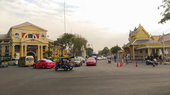 Bangkok, Thailand - January 11, 2018 : A pair of Tuk tuks or sam lor on road riding past Territorial Defense Command Building in Bangkok, Thailand