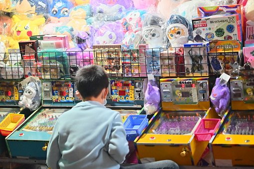 Taiwan - Feb 28, 2024: At a pinball stall in Ningxia Night Market in Taiwan, a close-up of a child playing a pinball machine, the player uses a pinball machine to launch the pinball.
