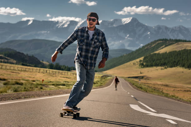 istock Happy skateboarder rides on longboard at mountain road 2150065783
