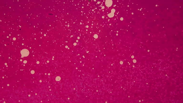 Graffiti spray can spreads pink paint across white speckled glass surface for transition