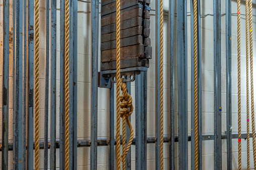 Older theatrical rigging system with twisted manila rope and weights found back stage.