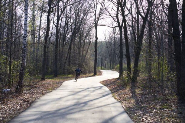 istock Cyclist riding on the road in the forest during springtime. Nature 2150070137