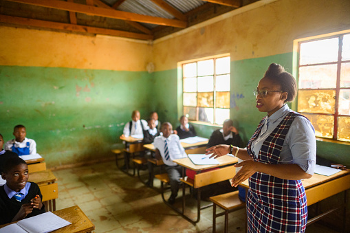 Female Teacher teaching a class of high school students in uniform in a rural school in Africa  Malealea, Lesotho.  The image allows for copy space.