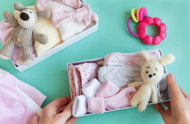 istock Women's hands collect children's clothes into boxes. 2150072979