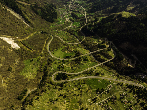 Aerial view of Mesocco village and winding roads surrounded by Alps, canton of Grisons.