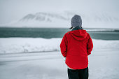 solo travel asian chinese woman standing in front of snowcapped mountain at Grundarfjörður, Iceland  in Winter