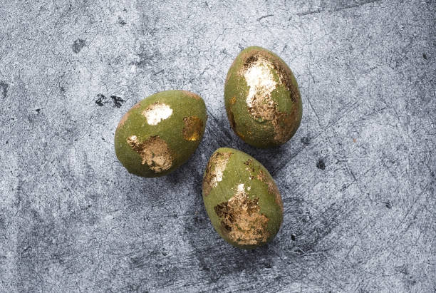istock Stylish olive-colored Easter eggs with a coating of golden sweat on a gray background. The concept of happy Easter 2024. 2150077516
