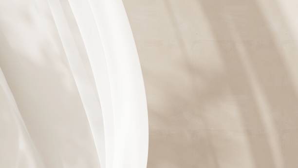 istock Smooth soft white sheer blowing curtain with beige wall in background 2150077723