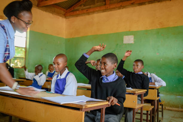istock Female school teacher in classroom with smiling learner student hand raised 2150078278