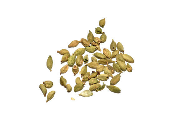 The spice cardamom beans is scattered on a white background and is used in cooking.