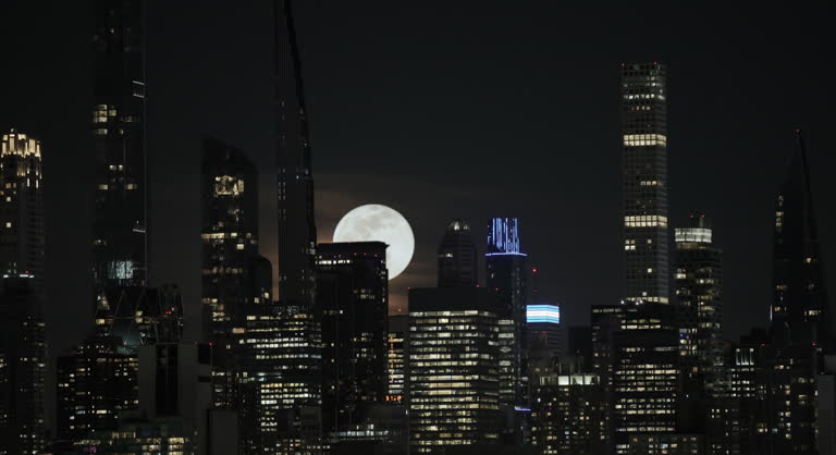 Full Moon Rising Up from Behind Manhattan Skyscrapers