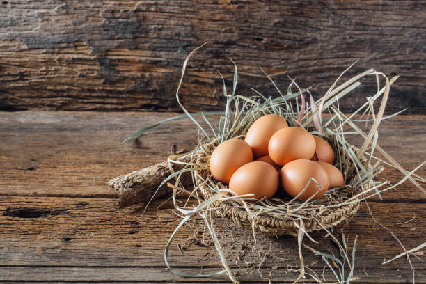istock Chicken eggs with hay on wooden background 2150079294