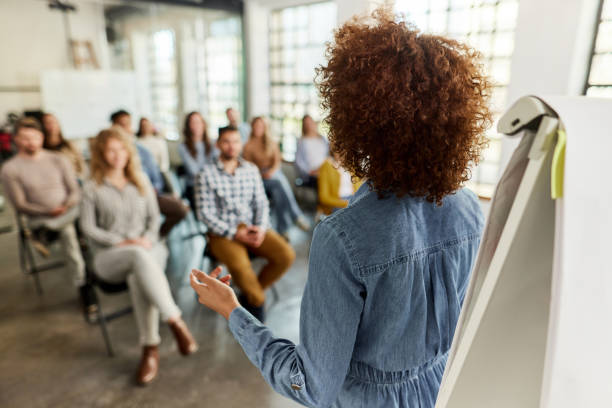 istock Back view of female speaker talking on presentation in the office. 2150080192