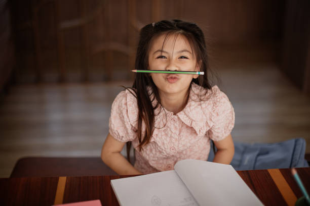 istock Girl playfully holds pencil as mustache 2150080688
