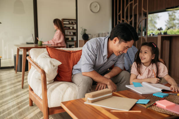 istock Girl doing homework with her father 2150080730