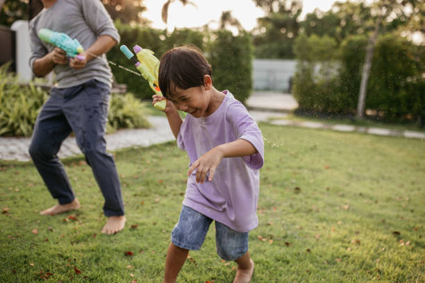 istock Father and son playing with water guns 2150081503