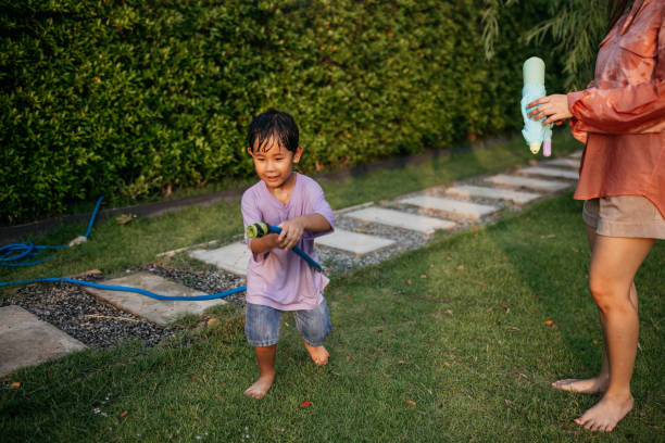 istock Toddler boy splashing with a garden hose 2150081533