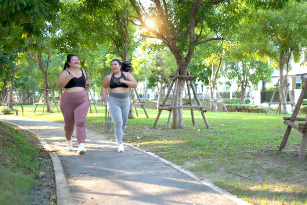 istock Oversize fat women running together at the park. 2150081803