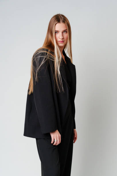 istock Young Woman Model in Black Top and Pants Posing on gray background 2150082103