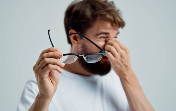 istock a man with narrowed eyes holds glasses in his hand on a light background vision problems 2150082239