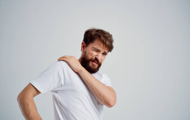 istock man touching shoulder with hand dislocation discomfort white t-shirt 2150082351
