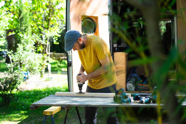 istock Caucasian man sanding a wooden strip to camperize a customized van 2150083310