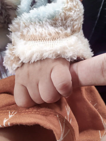 The baby's hand holds the parent's hand tightly, the most comfortable protection