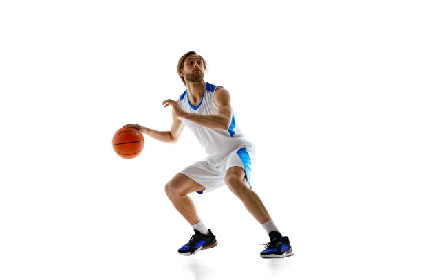 istock Skilled young man, basketball player in motion with ball demonstrating dribbling technique isolated on white background 2150083921