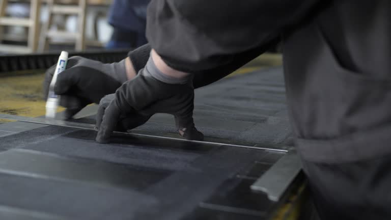 drawing white lines on black rubber in industrial production, closeup handheld