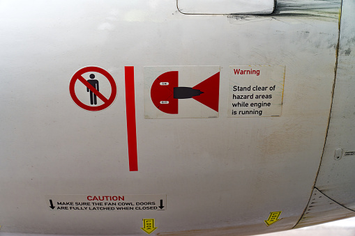 Close-up of warning signs and warning text outside of aircraft engine of parked passenger airplane at Swiss airport Zürich Kloten. Photo taken April 9th, 2024, Zurich, Switzerland.