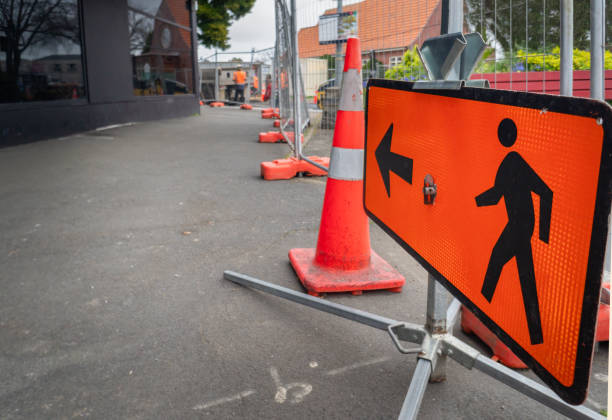 istock Man Walking Road sign along a closed footpath. Unrecognizable workers in the distance. Roadworks in Auckland. 2150088622
