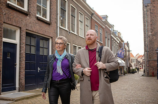 Beautiful senior woman walking through the centre of Delft on her day off with her male partner