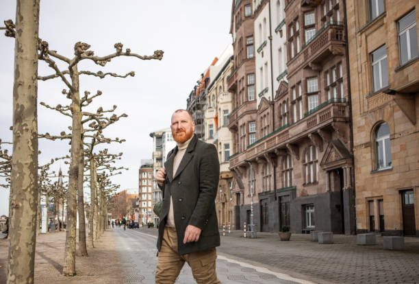 Handsome redhead tourist man exploring whilst walking in Dusseldorf, Germany
