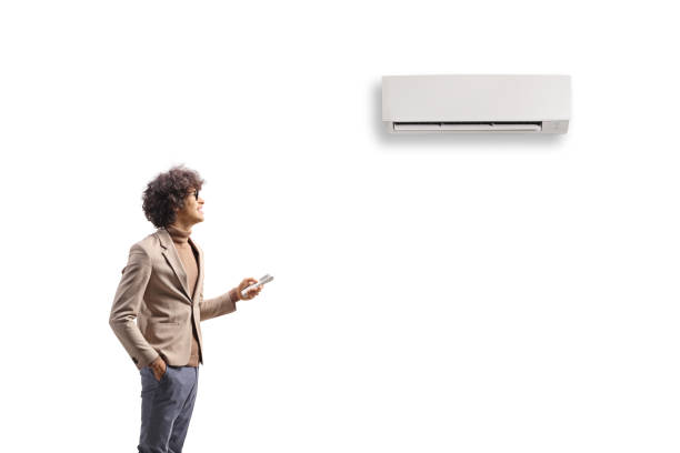 Young man putting on an air conditioner mounted on wall Young man putting on an air conditioner mounted on wall isolated on white background wall mounted air conditioner stock pictures, royalty-free photos & images