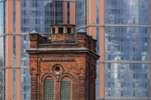 Old brick tower against the backdrop of a modern apartment building