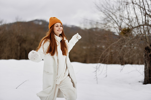 Happy young woman in winter clothes in hats outdoors winter holidays. High quality photo