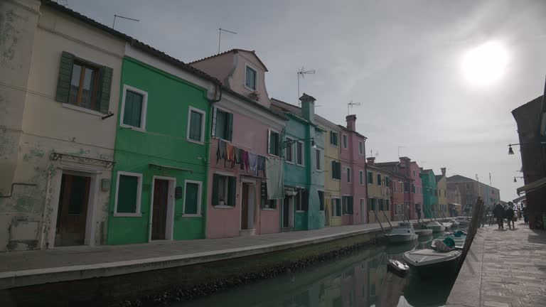 Canal-side Burano colorful pastel houses with laundry lines, Italy